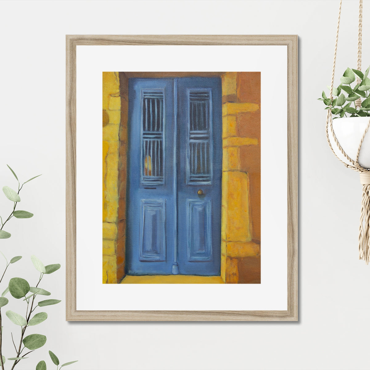 Blue Door art print, 16x20, in a natural frame with white mat, hanging on a wall in a furnished room